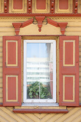 The window of an old wooden Russian house with beautiful decorative wood trims.