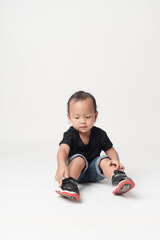 Asian boy wearing denim overalls is walking.