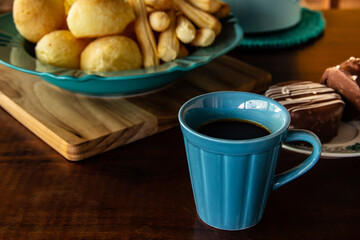 Mesa de café da manhã. Xícara de café com pão de queijo e biscoitos de queijo. Refeição típica brasileira.