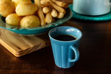 Mesa de café da manhã. Xícara de café com pão de queijo e biscoitos de queijo. Refeição típica brasileira.