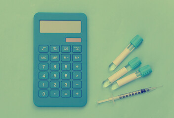 Test tubes, calculator and syringe on a blue background. Top view