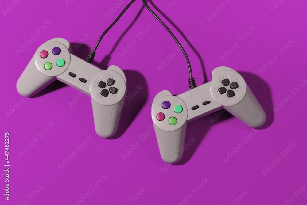 Poster retro gamepads on pink background with shadow. retro gaming. top view