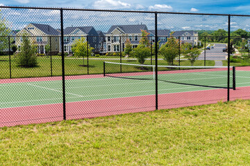 Tennis court with houses in the residential area - Powered by Adobe