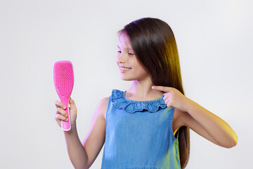 cute little child girl holding hair comb on white background