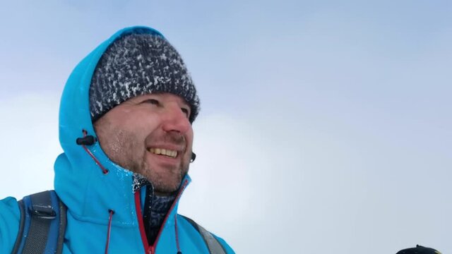 Tourist in a blue jacket shoots a selfie video high in the mountains