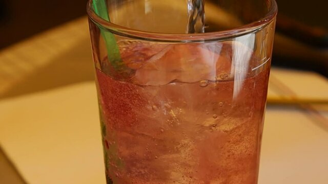 main remplissant un verre de limonade