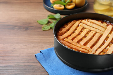 Delicious apricot pie in baking dish on wooden table. Space for text