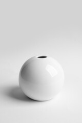 Stylish white ceramic vase on light background