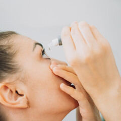 Young girl buries her eyes with special eye drops