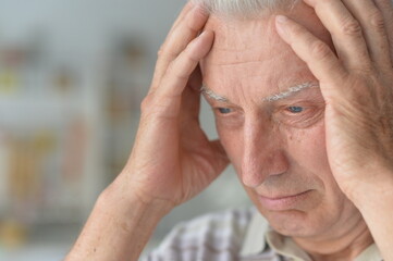 Portrait of sad sick senior man with headache