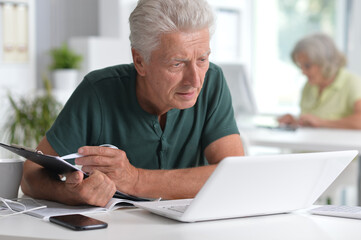 Obraz premium senior man using laptop in office