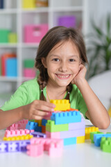 happy cute little girl playing with cubes