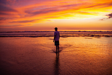 Fototapeta na wymiar Meeresküste / Strand im Abendrot mit einem Spaziergänger
