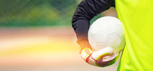 Goalkeeper with soccer ball in stadium sunlight, banner sport