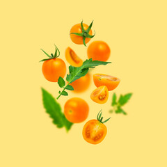 Flying ripe fresh yellow orange tomatoes with green leaves on yellow background flat lay. Cherry tomatoes. Vegetables, healthy vegan organic food, harvest concept, tomatoes pattern. Creative layout