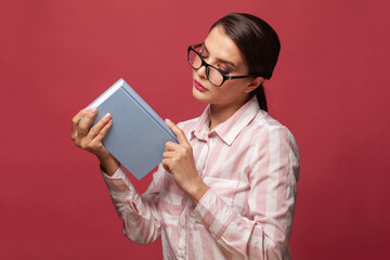 Clever young woman in glasses holding book with mock up copy space