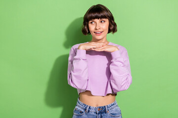 Portrait of attractive bewildered girl thinking looking aside copy space isolated over vibrant green color background