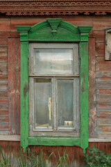 The window of an old wooden Russian house with beautiful decorative wood trims