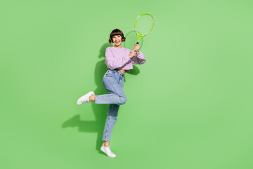 Fototapeta na wymiar Full length body size view of attractive cheerful girl playing tennis having fun isolated over bright green color background