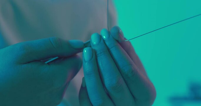 Close-up orthodontist hands are holding an archwire and by using dental forceps are clenching and bending archwire.