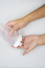 Hands using a plastic bottle of sanitizer