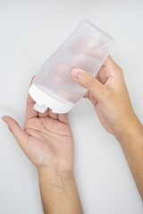 Hands using a plastic bottle of sanitizer