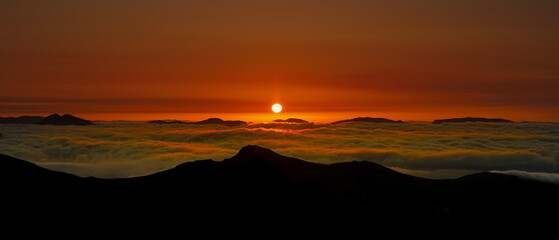Sunrise over the mountains of Glencoe with a Cloud inversion. located in the highlands of Scotland.