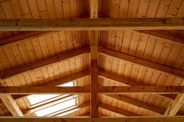 closeup of floor beams in attic of wooden barn, cottage roof with roof windows