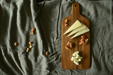 Spanish manchego cheese board with nuts and dried fruit on wooden board