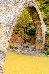 konitsa city arced bridge and voidomatis river in autumn , greece