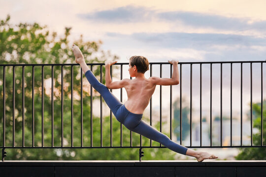 ballet dancer teen boy exercising on rooftop sunset sky background
