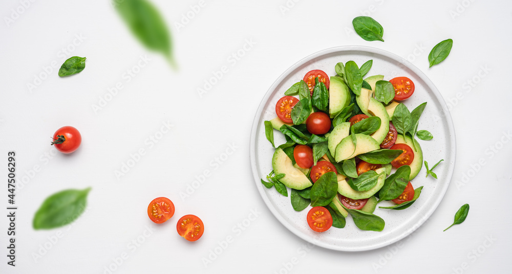 Wall mural Spinach avocado tomatoes salad. Healthy vegan food. White background, top view, copy space - Wall murals
