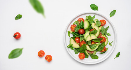 Spinach avocado tomatoes salad. Healthy vegan food. White background, top view, copy space