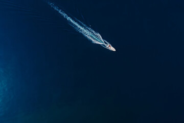 Speedy motor boat is sailing in blue ocean. Aerial view