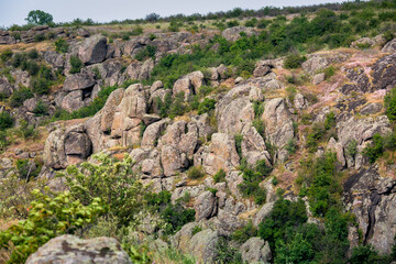 Fototapeta na wymiar mountain top with trees and granite stone ledges wildlife landscape with grass on a hillside on a summer day, a place for active tourism and hiking, nobody.