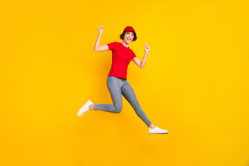 Fototapeta na wymiar Full size profile photo of nice hooray brown hair lady jump wear t-shirt cap isolated on yellow background