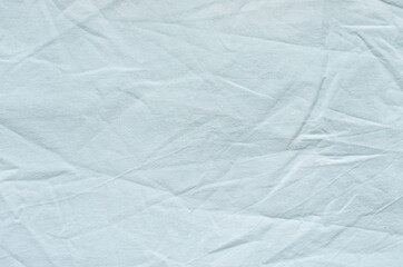 Top view of wrinkles on an unmade bed sheet after waking up in the morning.