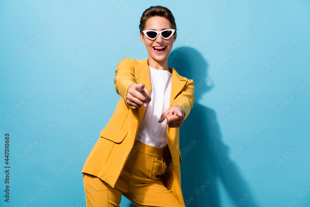 Wall mural Portrait of attractive cheerful woman having fun pointing at you sale shopping isolated over bright blue color background