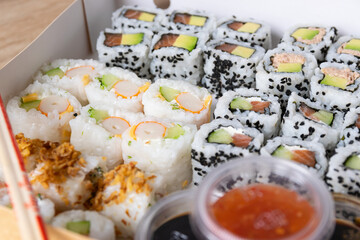Prepared and ready sushi set with sauces in an ecological paper box.