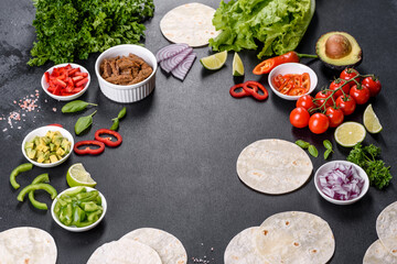 Mexican tacos with beef, tomatoes, avocado, onion and salsa sauce