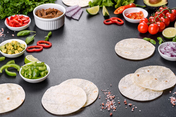 Mexican tacos with beef, tomatoes, avocado, onion and salsa sauce