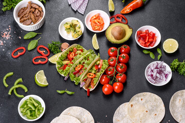 Mexican tacos with beef, tomatoes, avocado, onion and salsa sauce