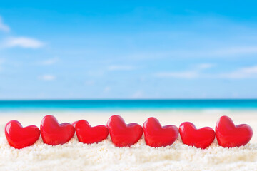 red heart shape on white sand beach 
