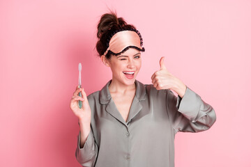 Portrait of attractive trendy cheerful girl cleansing teeth winking showing thumbup isolated over...