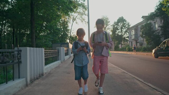 The schoolboys returning from school in a sunset time