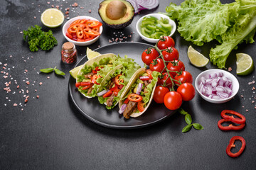Mexican tacos with beef, tomatoes, avocado, onion and salsa sauce