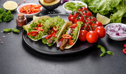 Mexican tacos with beef, tomatoes, avocado, onion and salsa sauce