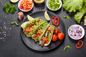 Mexican tacos with beef, tomatoes, avocado, onion and salsa sauce