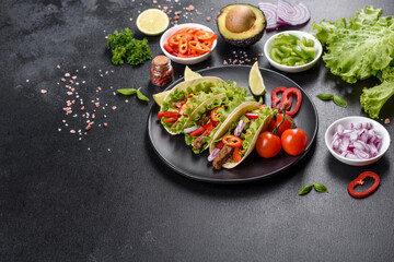 Mexican tacos with beef, tomatoes, avocado, onion and salsa sauce