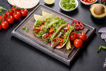 Mexican tacos with beef, tomatoes, avocado, onion and salsa sauce